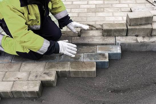 Worker leveling and repairing interlock pavers